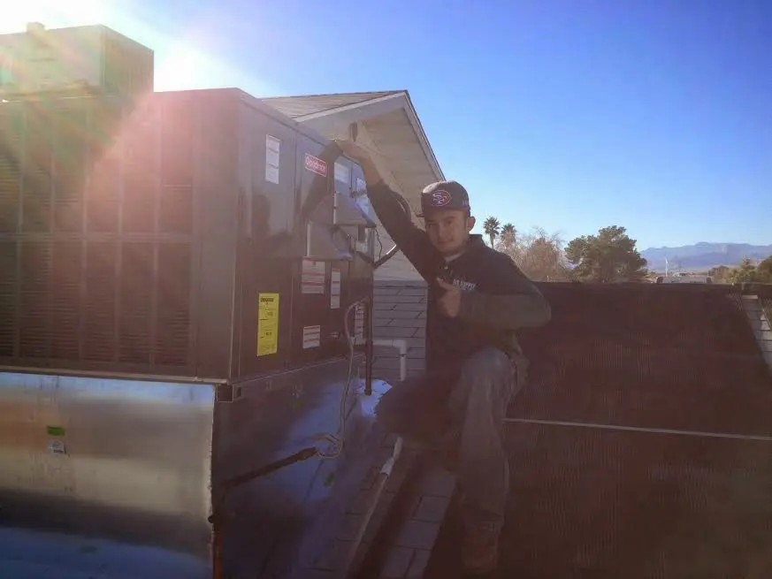 HVAC technician performing HVAC Inspection on a rooftop unit in Wilna
